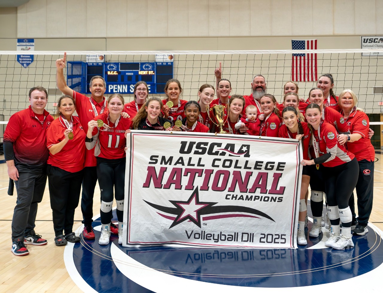 women's soccer team and coaches pose with championship banner
