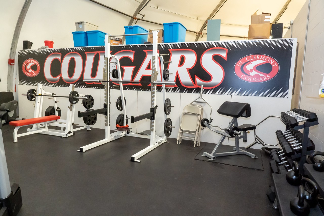 weight lifting equipment in the fitness area with Cougars written on the wall