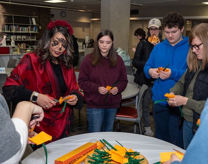 students gather around a table to do an interactive craft project